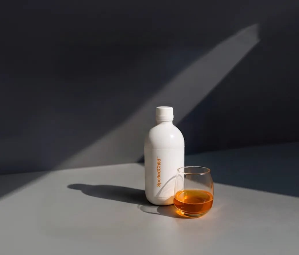 E27 Extra Strength Liquid Collagen beside a poured glass